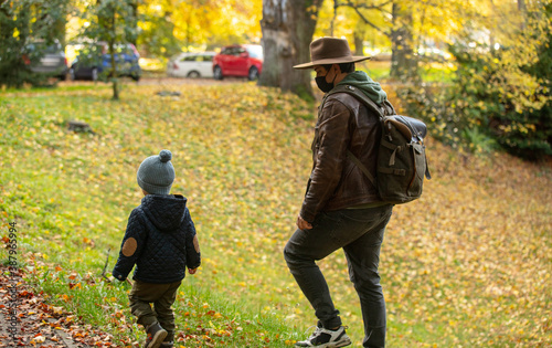 father and son walk in the park in autumn