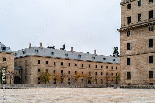 El Escorial or the Royal Site of San Lorenzo de El Escorial, view a foggy day in Autumn with morning light photo