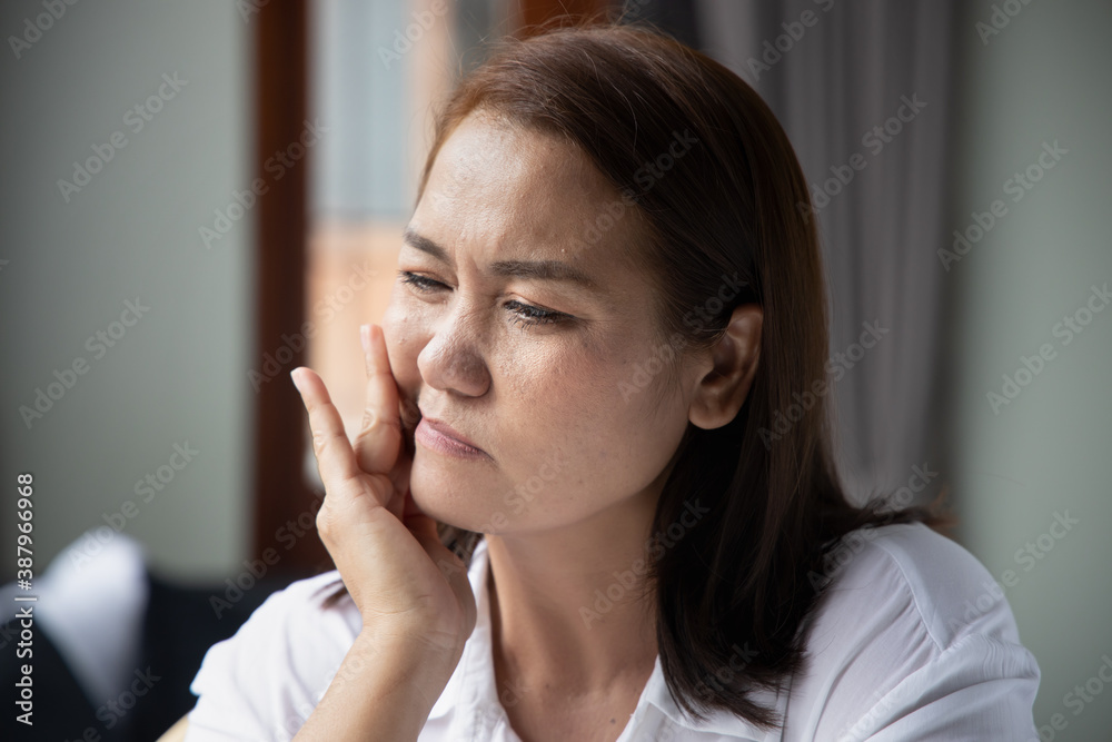asian middle aged woman suffering from toothache, tooth decay, tooth sensitivity; oral health care concept asian middle aged woman suffering from toothache, tooth decay, tooth sensitivity; oral health care concept
