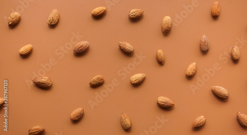 pattern of almonds arrange on brown background 