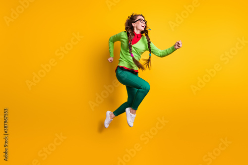 Full length body size view of attractive funky cheerful girl jumping running motivation isolated bright yellow color background
