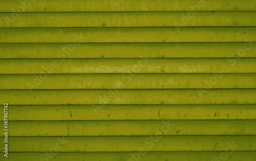 Bretterwand mit gelb gr  ner Farbe als Hintergrund