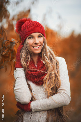 Portrait of smiling woman wearing woolen accessories. Young woman in beautiful autumn park, concept autumn
