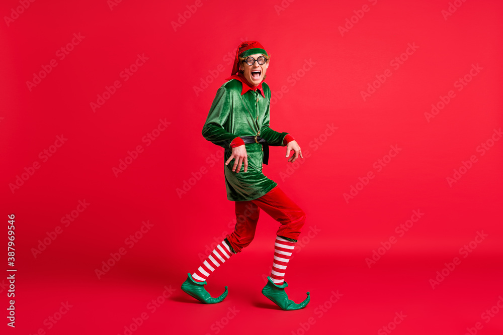 Full body profile side photo of crazy naughty elf sneak x-mas copyspace wear christmas headwear isolated on shine color background Full body profile side photo of crazy naughty elf sneak x-mas copyspace wear christmas headwear isolated on shine color background