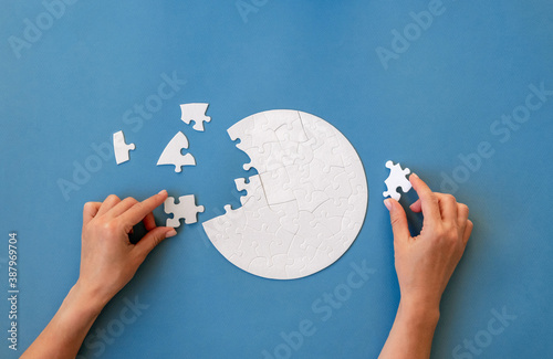 Hand putting piece in round puzzle photo