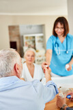 Caregiver distributes medicines to senior