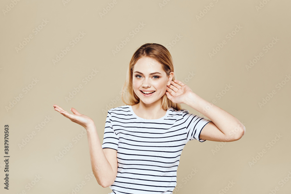 Cheerful woman striped t-shirt studio beige background lifestyle emotions Cheerful woman striped t-shirt studio beige background lifestyle emotions