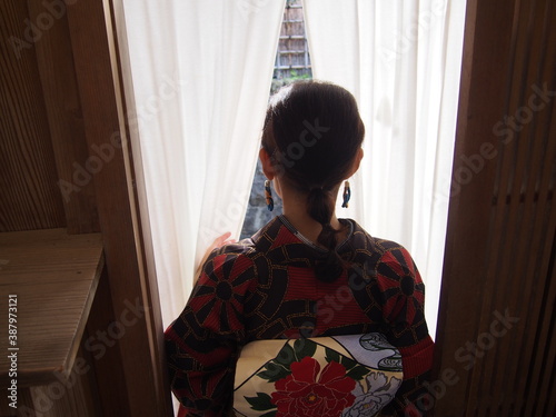 The back of a woman wearing a kimono leaving a ryotei (Japanese-style restaurant), Kyoto, Japan