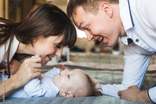 Mom and dad with a small son at home, newborn baby, home and comfort, communication with the child