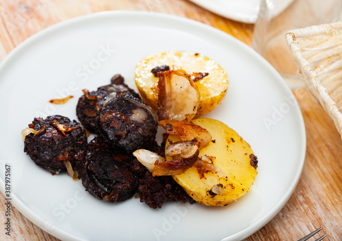 Delicious blood sausages with garnish of potatoes and grilled onion