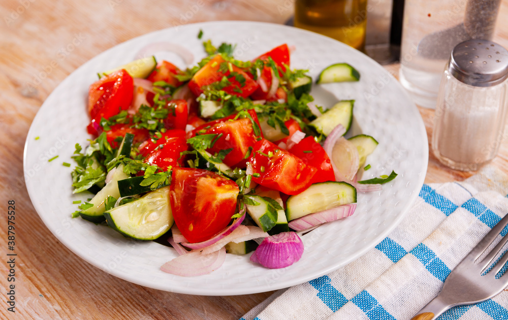 Delicious vegetable salad with tomato, cucumber and onion on plate