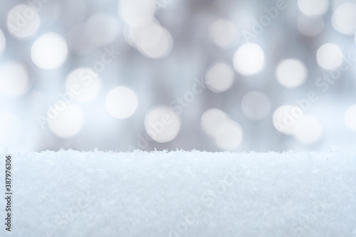 Winter background with snow drifts and holiday lights in bokeh (copy space, blurred) © Mikhail