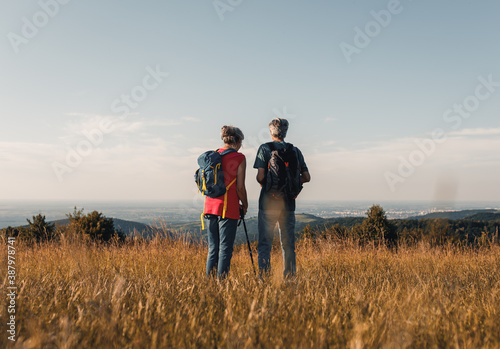 Active senior couple hiking in nature with backpacks, enjoying their adventure in nature.