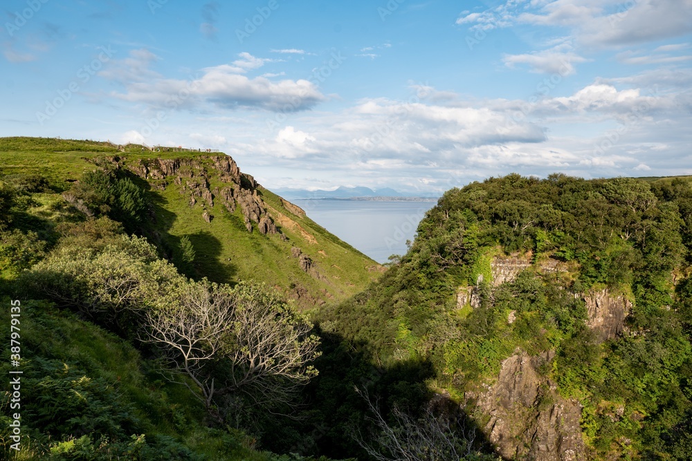 Scottish landscape with hills and gorge near Staffin at Isle of Skye with green pastures Scottish landscape with hills and gorge near Staffin at Isle of Skye with green pastures