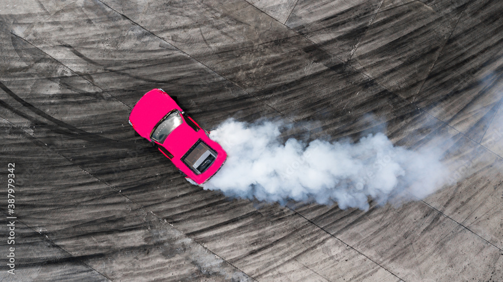 Aerial top view professional driver drifting car on asphalt road track with white smoke, Automobile race car drift on abstract asphalt road with black tire skid mark, View from above.