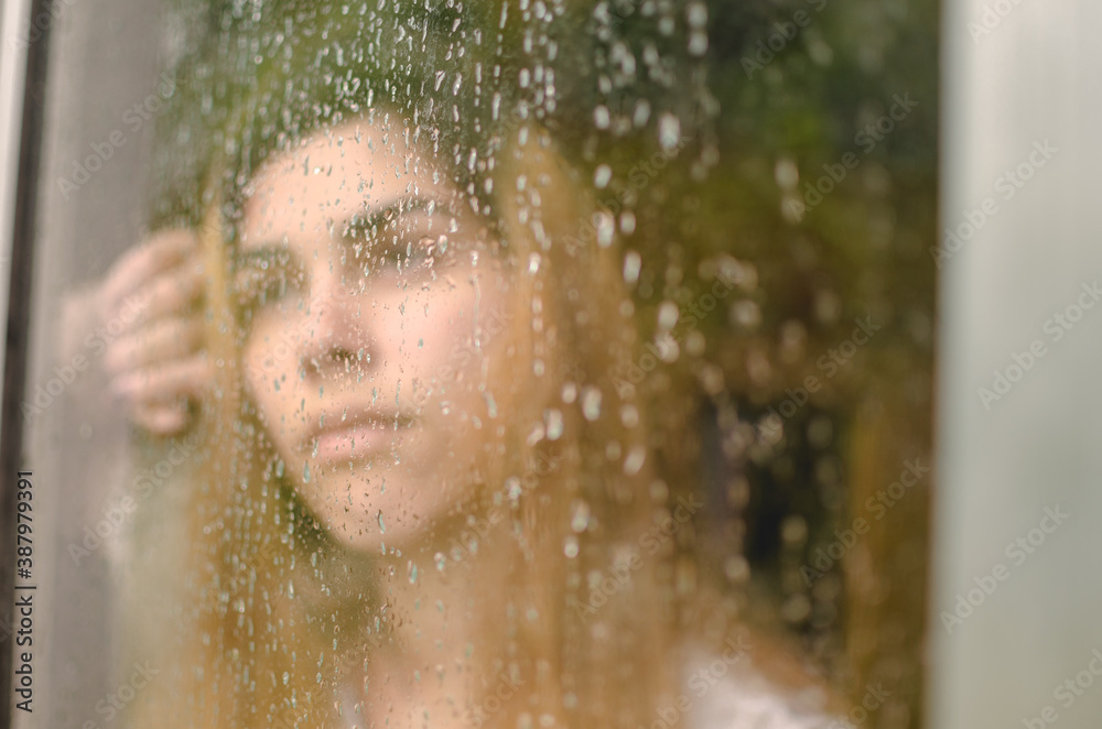 reflection of woman in front of the window on a rainy day