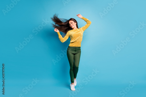 Fototapeta Naklejka Na Ścianę i Meble -  Photo portrait full body view of girl dancing with flying hair isolated on pastel blue colored background
