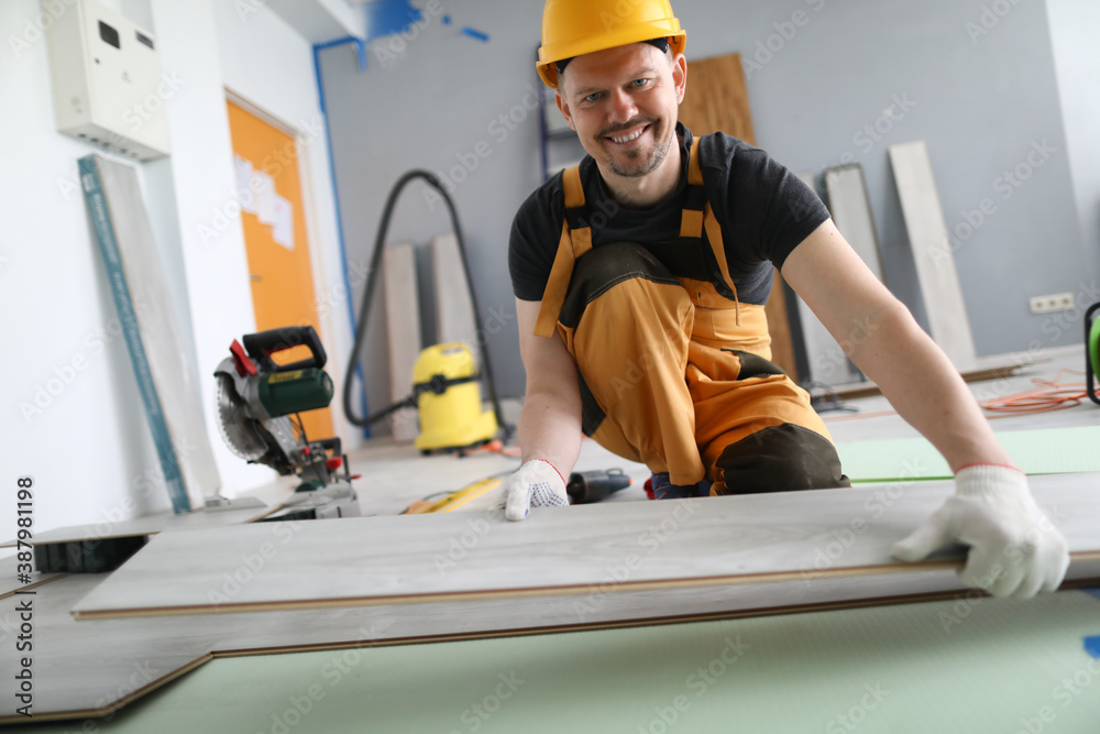 Man builder holds laminate board in his hands. Repair and decoration services for apartments and houses concept Man builder holds laminate board in his hands. Repair and decoration services for apartments and houses concept