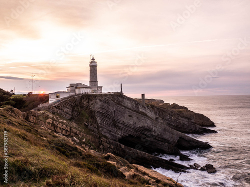 An amazing sunset with a lighthouse landscape in the north coast of Spain