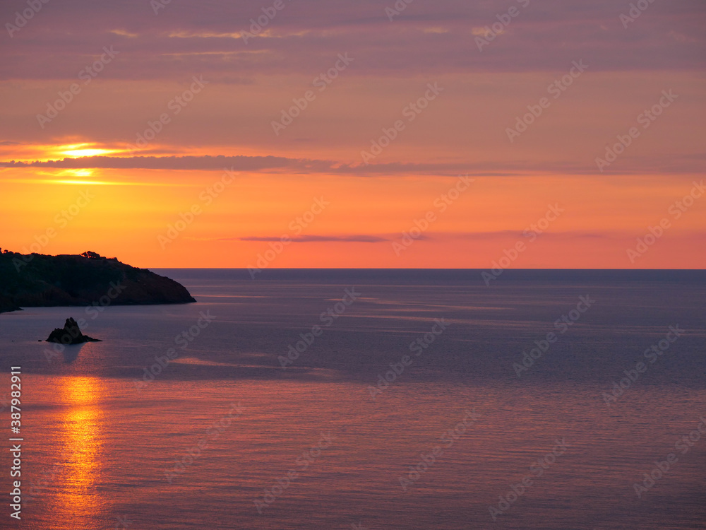 Magnigique lever de soleil derrière un rocher sur la Côte d'Azur.