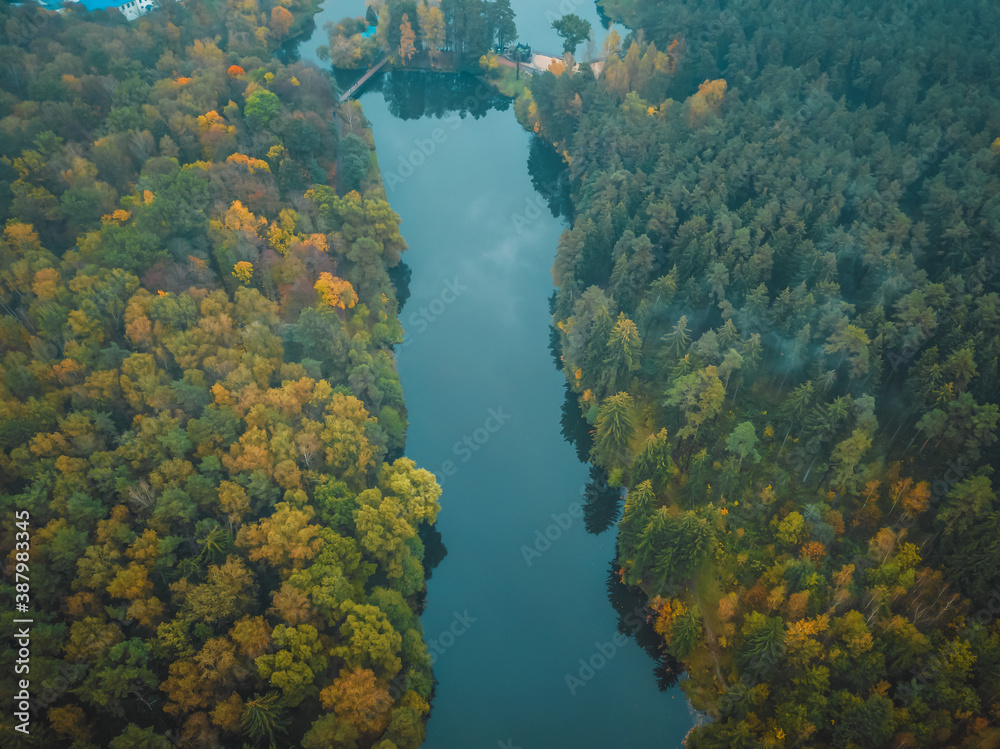 view from the bird's eye view of the beautiful river and colorful autumn forest on a cloudy day, the photo with the drone.
