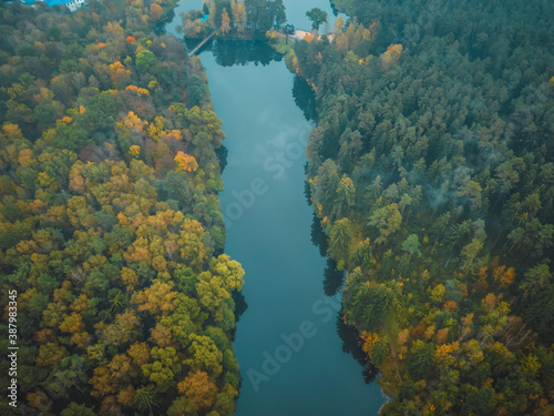view from the bird s eye view of the beautiful river and colorful autumn forest on a cloudy day  the photo with the drone.