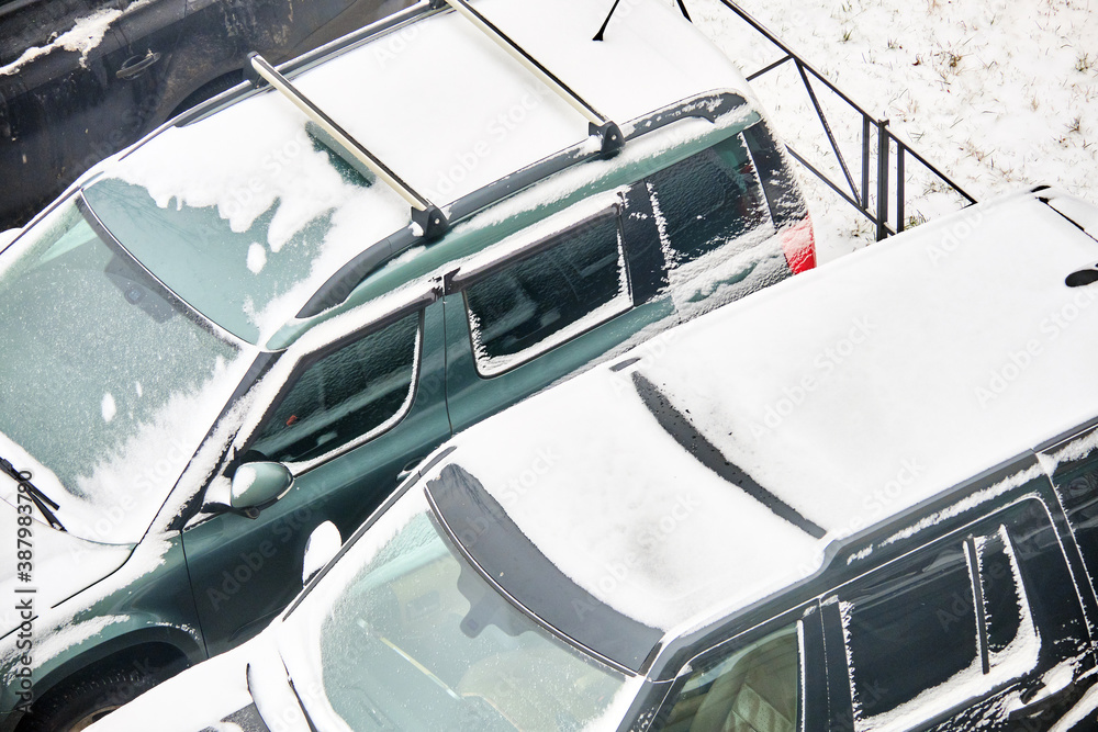 Cars covered with snow in winter in a parking lot