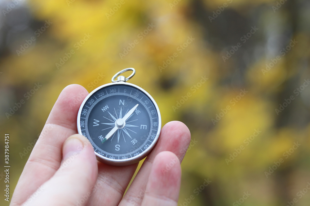 Classic navigation compass on natural background as symbol of tourism with compass, travel with compass and outdoor activities with compass Classic navigation compass on natural background as symbol of tourism with compass, travel with compass and outdoor activities with compass