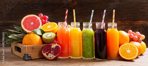 bottles of fruit juice with fresh fruits