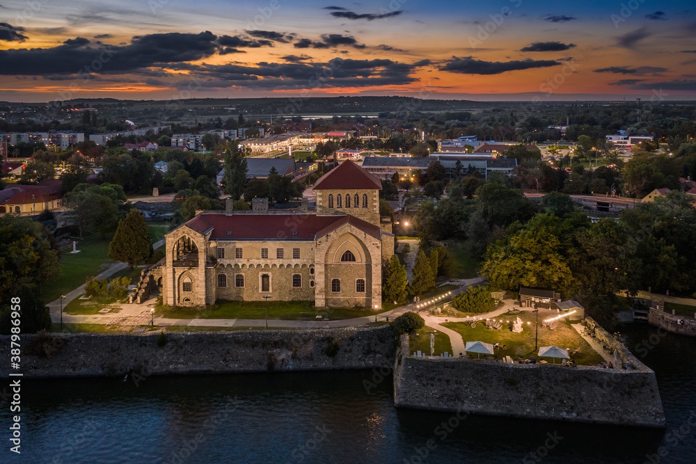 Fototapeta premium Tata, Hungary - Aerial view of the beautiful illuminated Castle of Tata by the Old Lake (Öreg-to) at dusk with colorful sunset clouds on a summer night