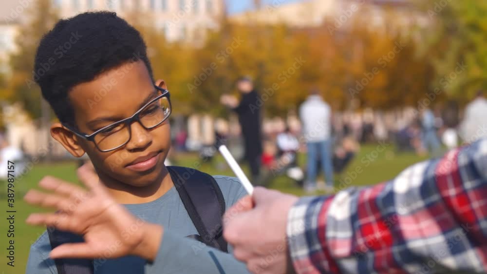 African preteen boy refusing cigarette offered by dealer ...