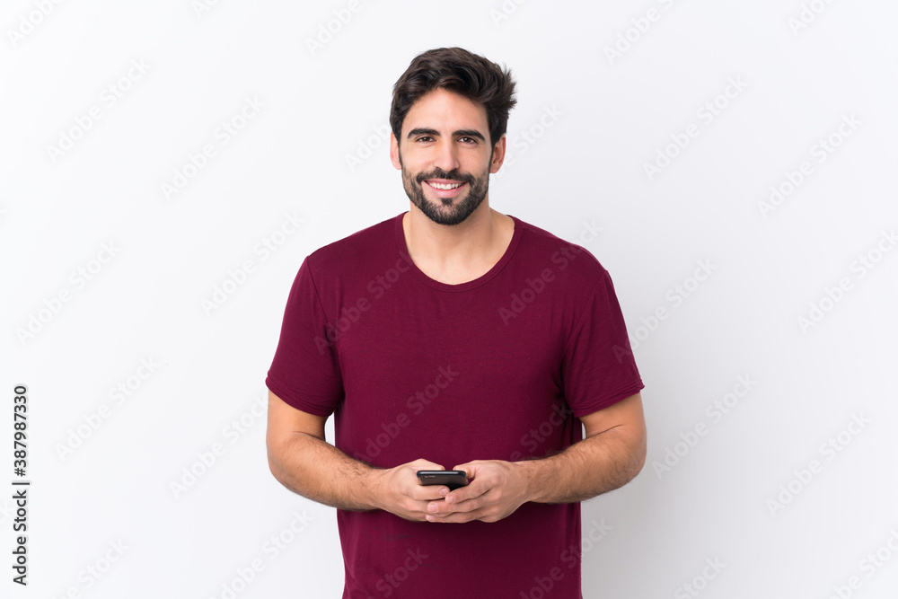 Fototapeta premium Young handsome man with beard over isolated white background sending a message with the mobile