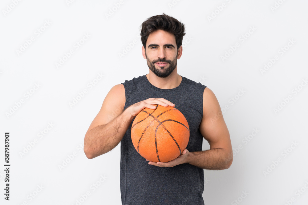 Young handsome man with beard over isolated white background playing basketball