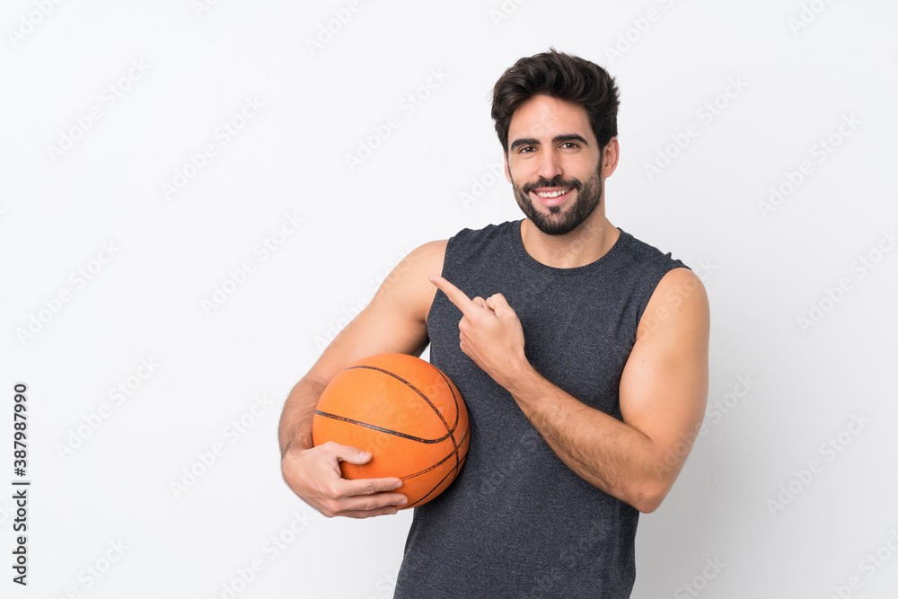 Basketball player man with beard over isolated white background pointing to the side to present a product Basketball player man with beard over isolated white background pointing to the side to present a product
