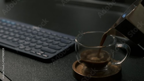 Bangkok, Thailand - Oct 25, 2020: Pouring black coffee in cup. Coffee with chocolate truffles. Cup of black coffee on wooden table,bialetti brikka brand , Italian coffee is  photo