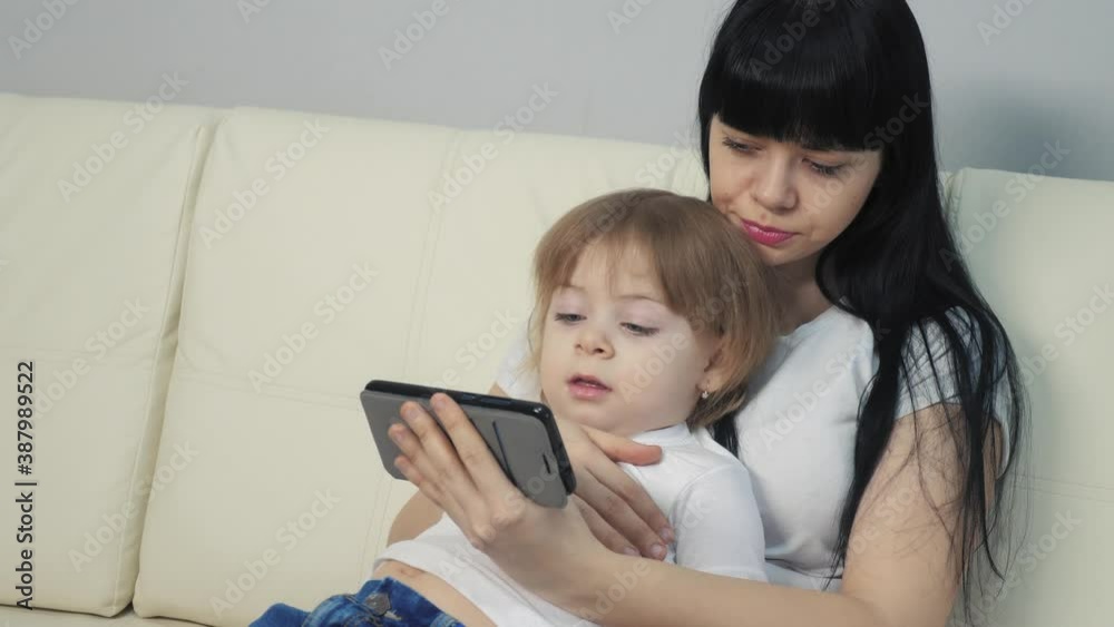 girl mom and little kid girl daughter surfs the page online online on a smartphone. mother and child daughter lifestyle watching online shopping at a shopping store girl mom and little kid girl daughter surfs the page online online on a smartphone. mother and child daughter lifestyle watching online shopping at a shopping store