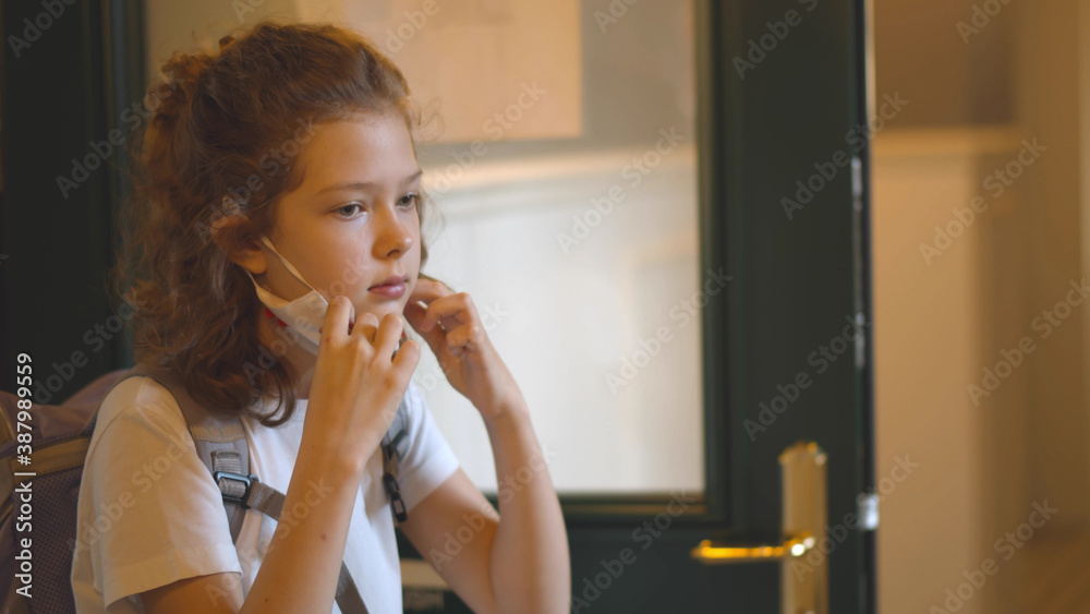 Portrait of kid walking out if classroom and putting on safety mask Portrait of kid walking out if classroom and putting on safety mask
