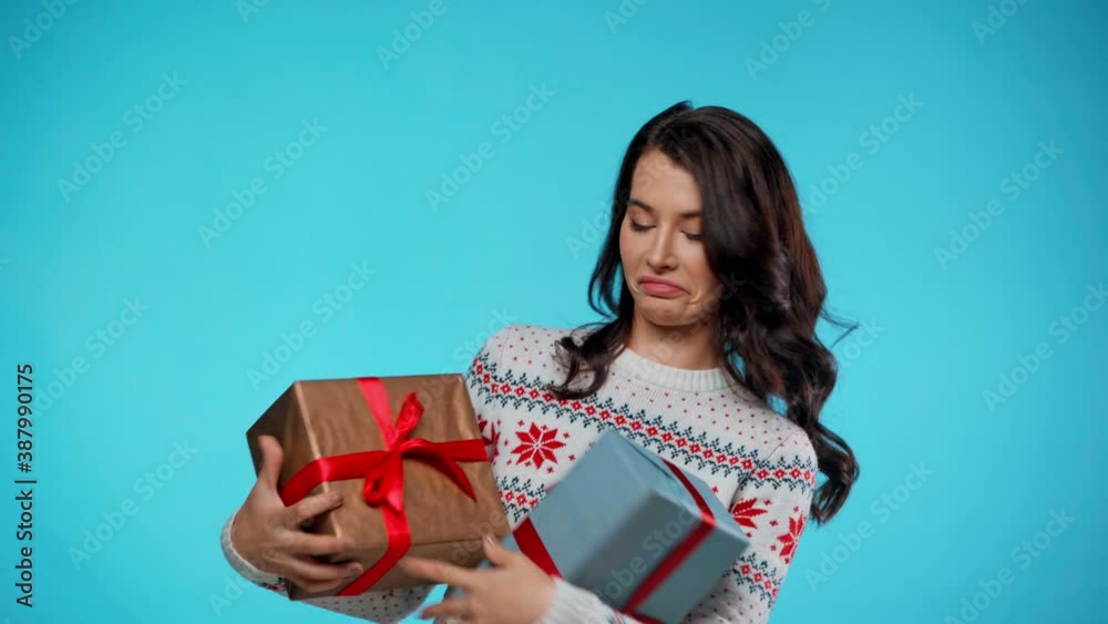 Happy young adult woman catching gift boxes on blue Happy young adult woman catching gift boxes on blue
