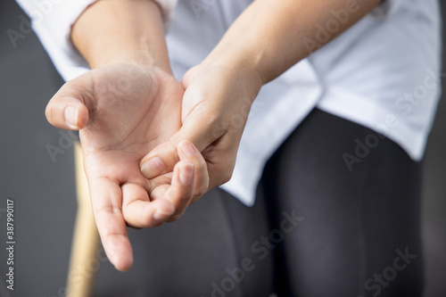 asian middle aged woman suffering from trigger finger, cps or carpal tunnel syndrome, gout disease, arthritis inflammation photo