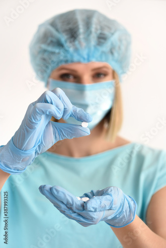 Hand of a doctor shows the pill to be taken to her patient. Healthcare and medical concept.