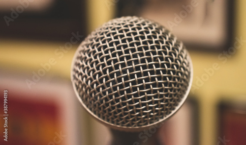 Close up on a metal microphone, with a blurry background