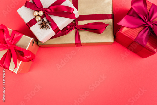 Top view of gift boxes with beads and anise star on red background, new year concept