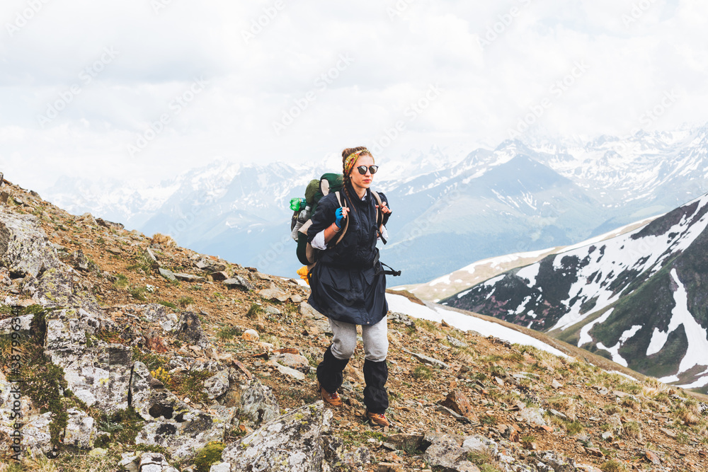 Traveling Woman tourist with backpack hiking in mountains