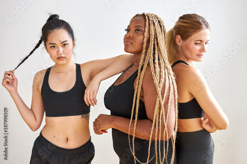 young group of mixed race fitness team stand isolated on white background, different ethnicity models portrait. body positive, sport as lifestyle.