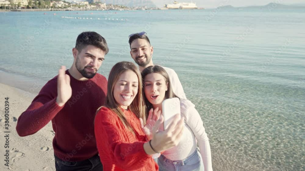 Group of caucasian young friends conference call from sea touristic location in fall-winter - Millennials using smartphone to share their travel fun on social networks - New communication technology Group of caucasian young friends conference call from sea touristic location in fall-winter - Millennials using smartphone to share their travel fun on social networks - New communication technology