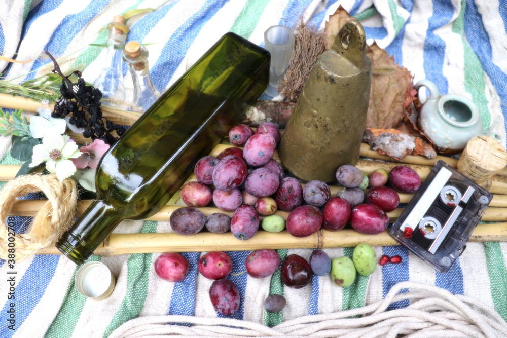 Fresh olives with an oil bottle, old bell and cassette tape on blue and white background