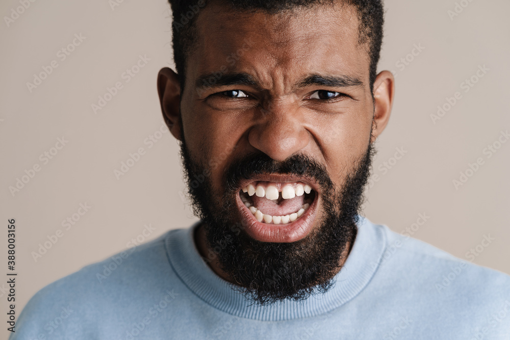 Angry african american guy looking and screaming at camera Angry african american guy looking and screaming at camera