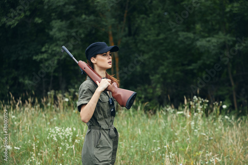 Woman With a gun on his shoulder, a black cap is a way of life for hunting green overalls 