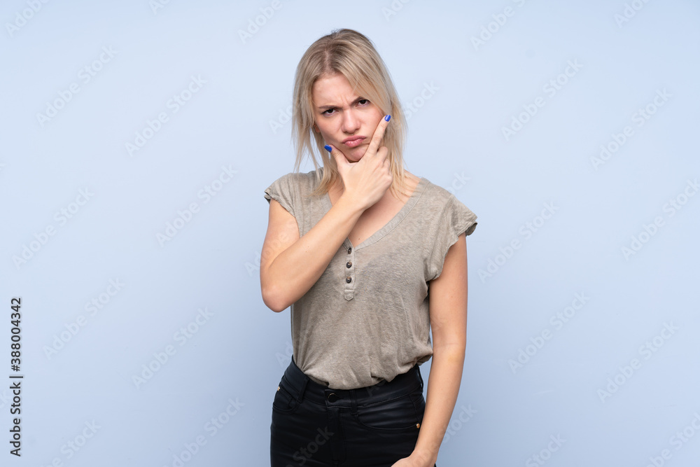 Young blonde woman over isolated blue background thinking an idea Young blonde woman over isolated blue background thinking an idea