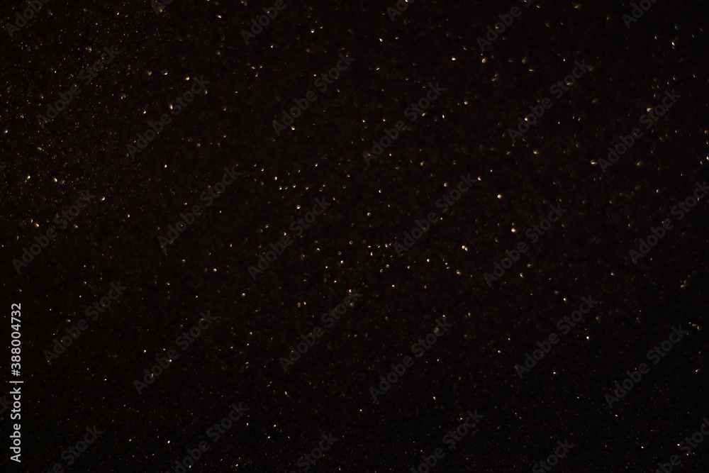 Black shiny glitter background, glowing blurred pattern for Christmas and New Year cards